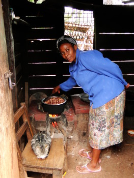 Woman cooks Githeri, a traditional Kenyan dish, over a modified, fixed stove. The stove has been built in a way that will allow it to burn more efficiently and produce less smoke.