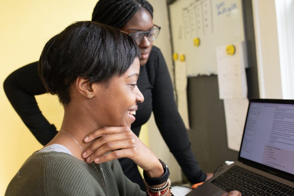 Woman in office smiling while using a computer. 